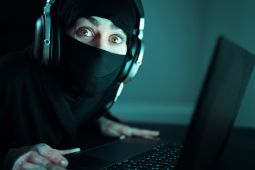 A social engineer sitting behind a laptop.