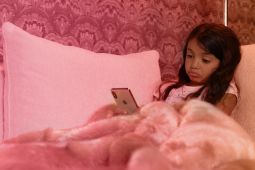 A sad young girl using a mobile phone.