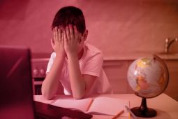A young boy covering his eyes with hands after seeing something inappropriate on the Internet.