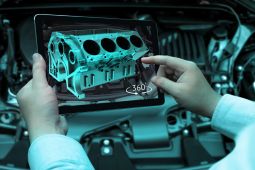 A man using Augmented reality technology as part of his work in car industries.