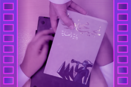 A hand of someone handing an other person a book.
