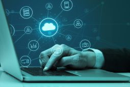 Hand on the keyboard of a laptop typing with one finger, and there is an illustration of a cloud representing a cloud service.